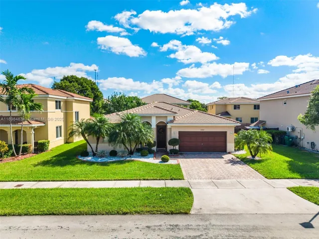 a front view of a house with a garden and plants