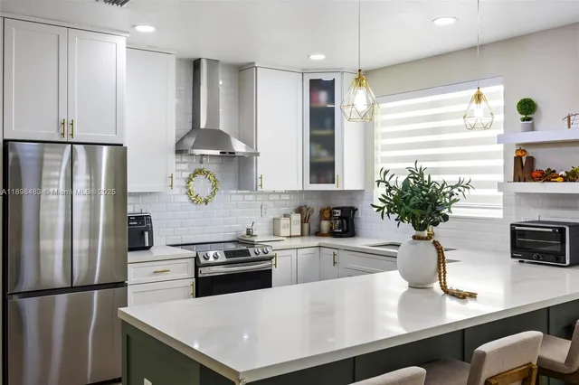a kitchen with a refrigerator and a white cabinets