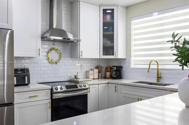 a kitchen with stainless steel appliances granite countertop a sink a stove and a microwave