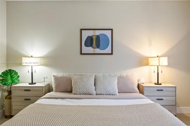 a bedroom with a bed and lamp painting on the wall