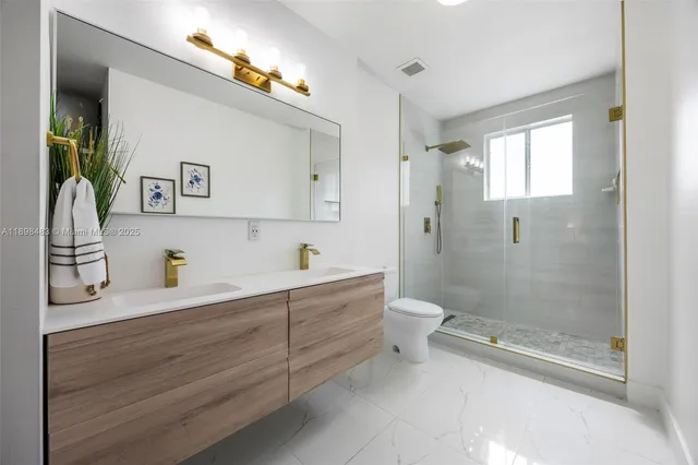 a bathroom with a granite countertop sink a toilet and shower