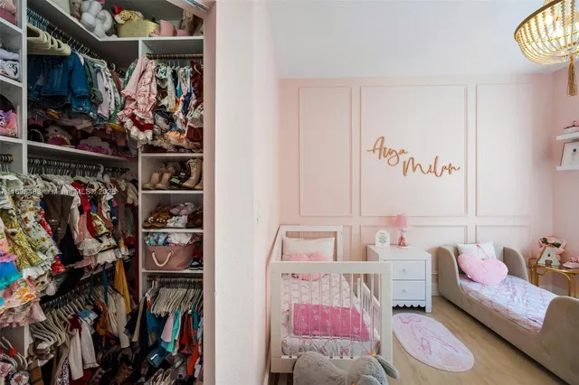 a view of walk in closet with clothes and shoes