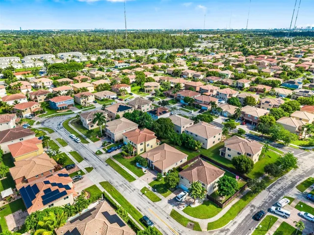 an aerial view of residential houses with outdoor space and street view
