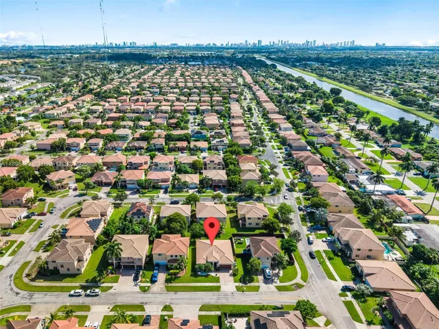 an aerial view of residential houses with outdoor space and parking