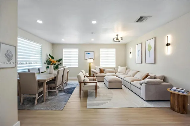 a living room with furniture wooden floor and a window