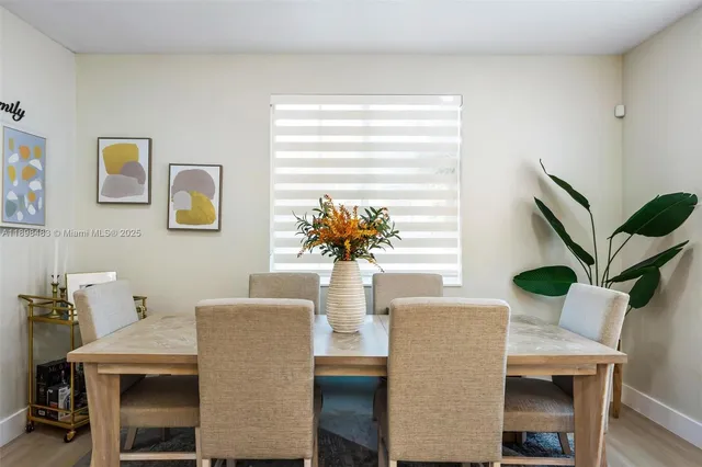 a view of a dining room with furniture and a potted plant