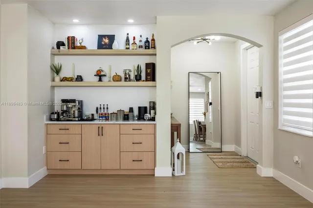 a kitchen with granite countertop white cabinets and wooden floor
