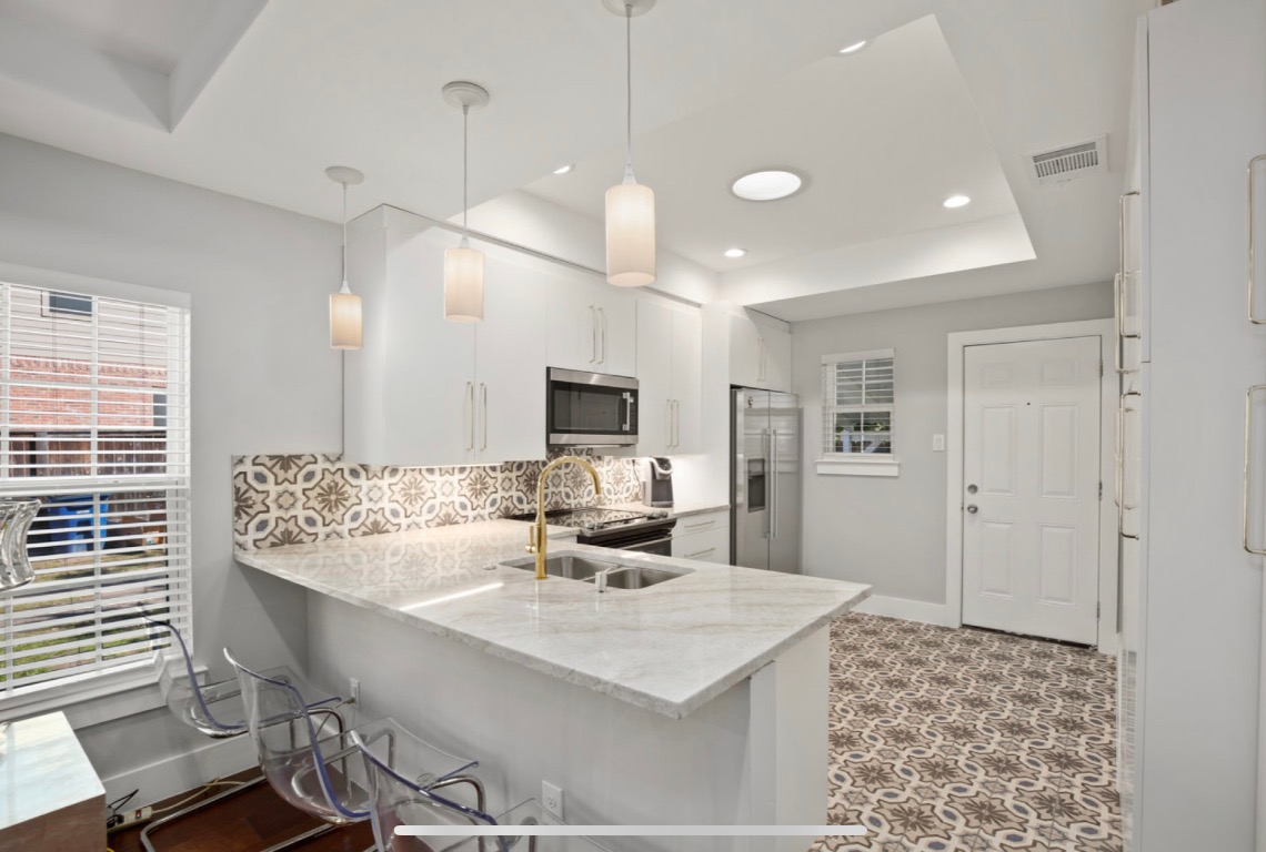 1305 Olander Street Austin, TX 78702 - Photo 7 of 14 a kitchen with kitchen island a sink dining table and chairs