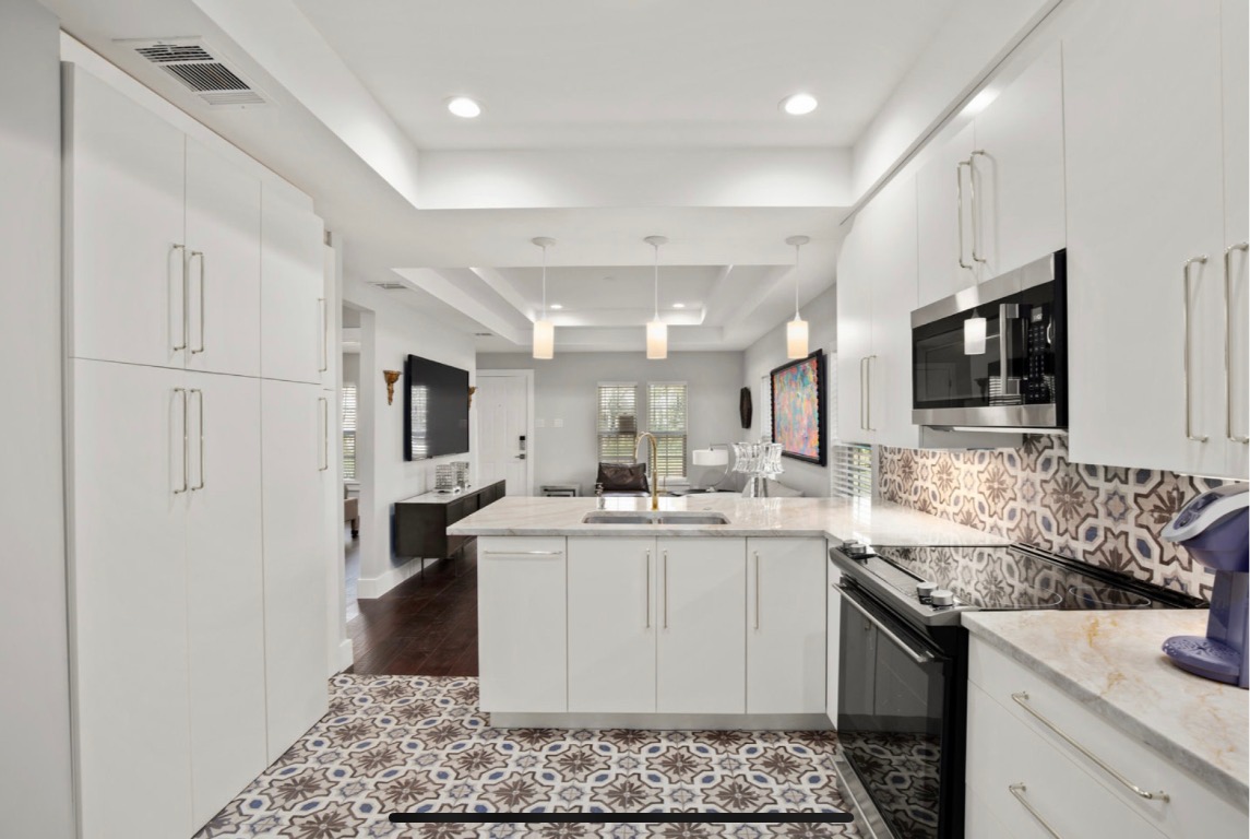 1305 Olander Street Austin, TX 78702 - Photo 9 of 14 a kitchen with a sink stove and cabinets