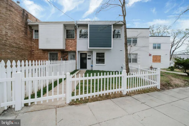 a view of a house with a small yard and wooden fence