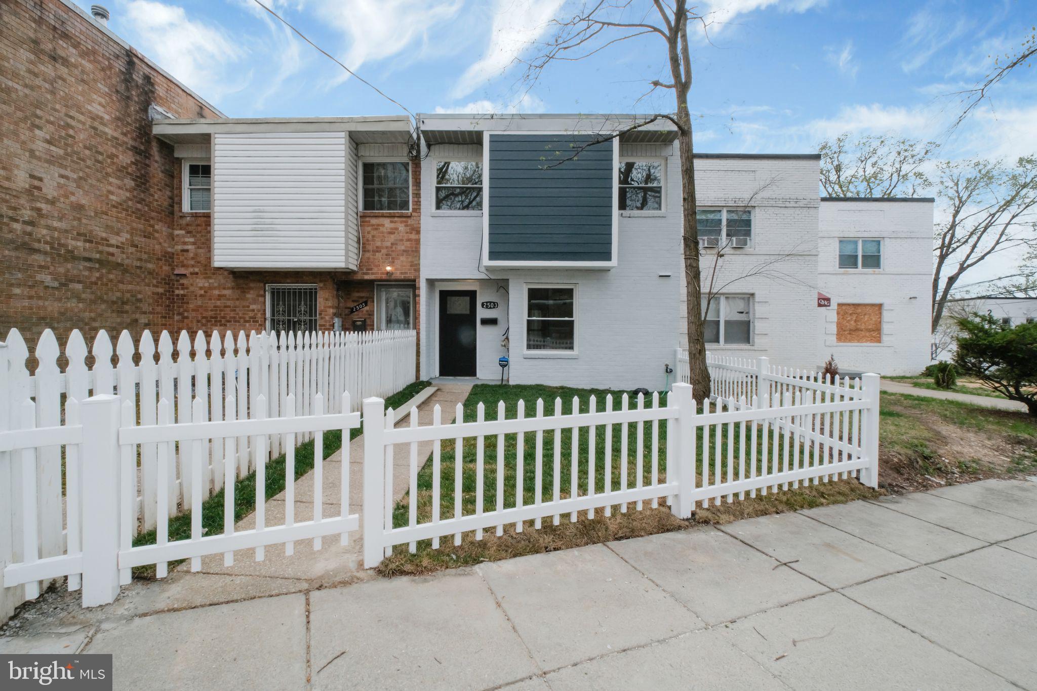 a view of a house with a small yard and wooden fence