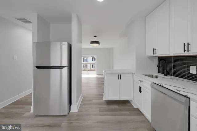 a kitchen with white cabinets and refrigerator