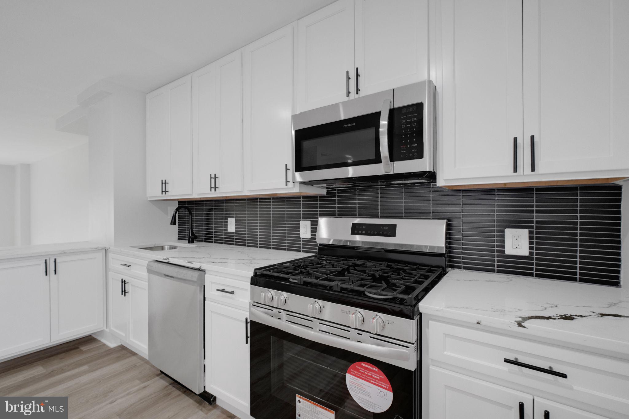 2503 Naylor Road Southeast Washington, DC 20020 - Photo 13 of 31 a kitchen with stainless steel appliances granite countertop grey cabinets a stove a sink and dishwasher