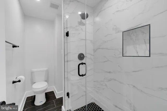a bathroom with a toilet shower and a shower