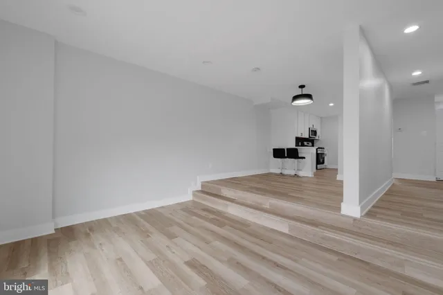 a view of empty room with wooden floor