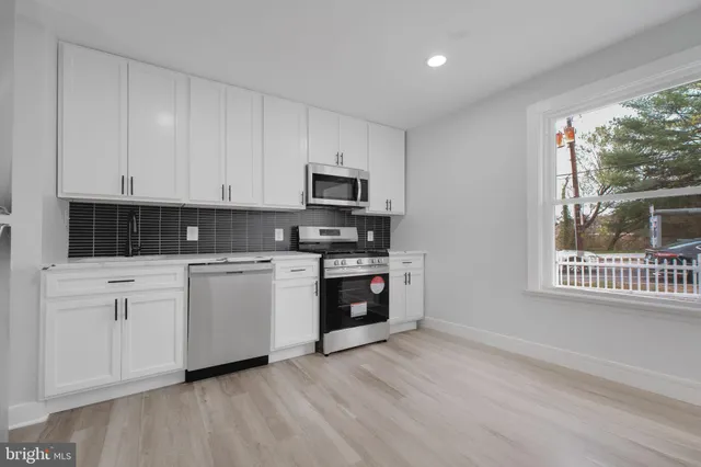 a kitchen with granite countertop a stove a sink and a microwave