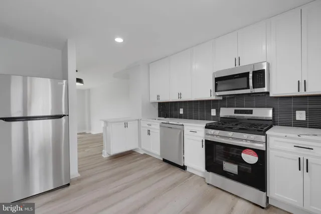 a kitchen with granite countertop white cabinets and stainless steel appliances