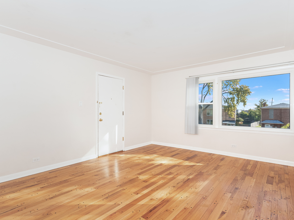 10548 Mason Avenue, Unit 2 Chicago Ridge, IL 60415 - Photo 3 of 13 a view of empty room with wooden floor and fan