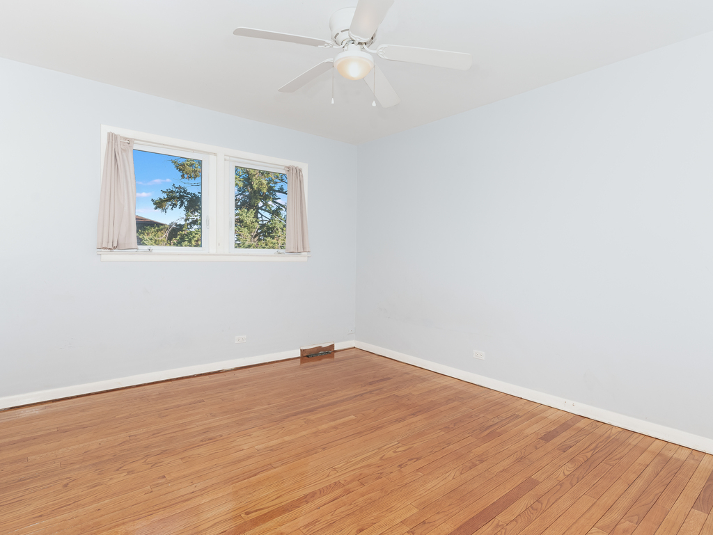 10548 Mason Avenue, Unit 2 Chicago Ridge, IL 60415 - Photo 5 of 13 an empty room with wooden floor and windows