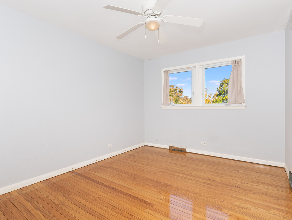 10548 Mason Avenue, Unit 2 Chicago Ridge, IL 60415 - Photo 7 of 13 an empty room with wooden floor closet fan and windows