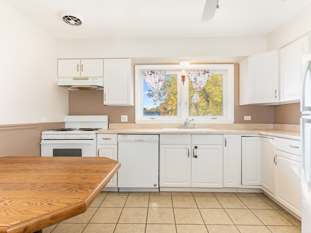 10548 Mason Avenue, Unit 2 Chicago Ridge, IL 60415 - Photo 10 of 13 a kitchen with white cabinets and white appliances