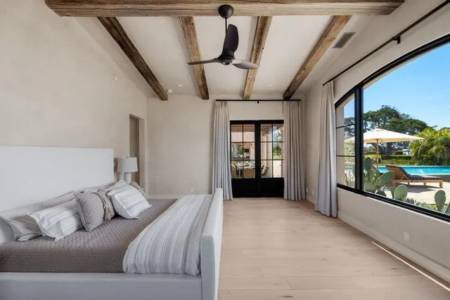 a bathroom with double vanity sinks a large mirror and a bathtub