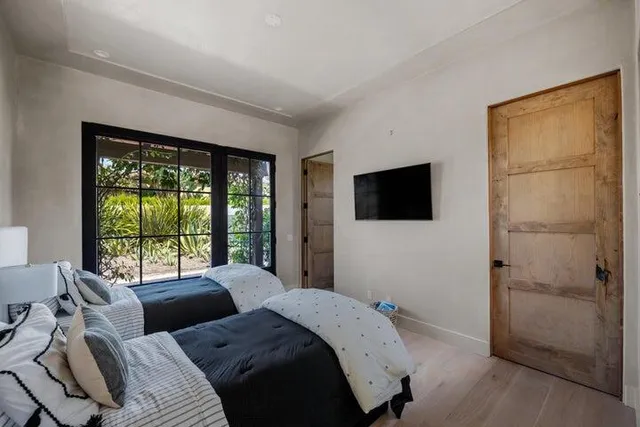 a living room with furniture a flat screen tv and floor to ceiling windows