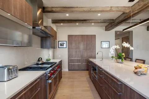 a large white kitchen with a large window