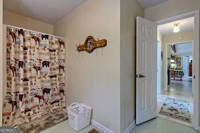 a view of a white house with a big yard and large trees