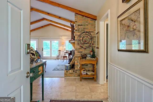 a living room with furniture a fireplace and a floor to ceiling window