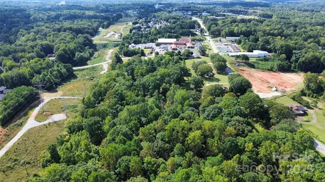 an aerial view of residential house with outdoor space and trees all around