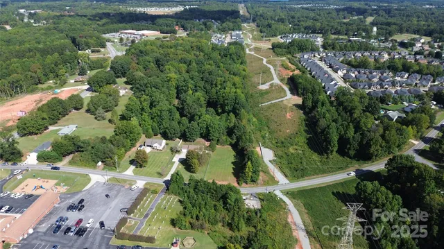 an aerial view of residential houses with outdoor space and trees