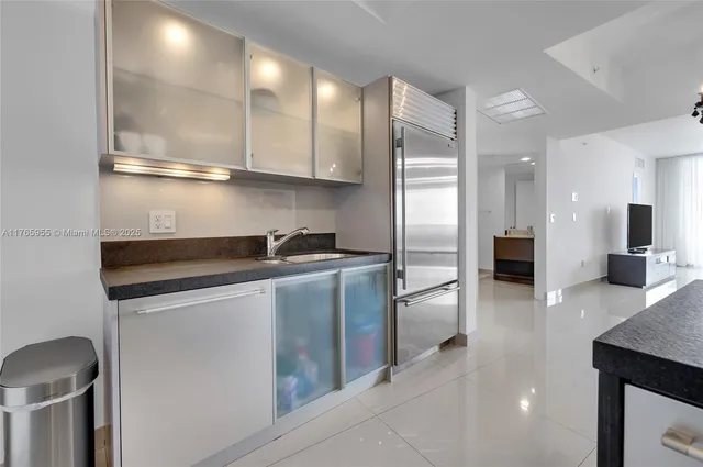 a kitchen with stainless steel appliances granite countertop a refrigerator and a sink