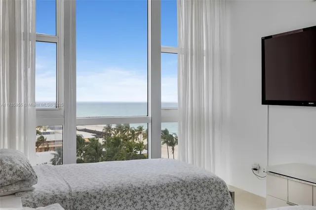 a bedroom with a bed and large window