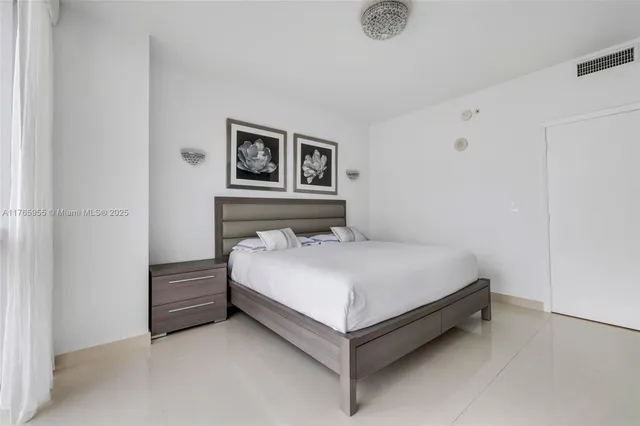 a bedroom with a bed and painting on the wall