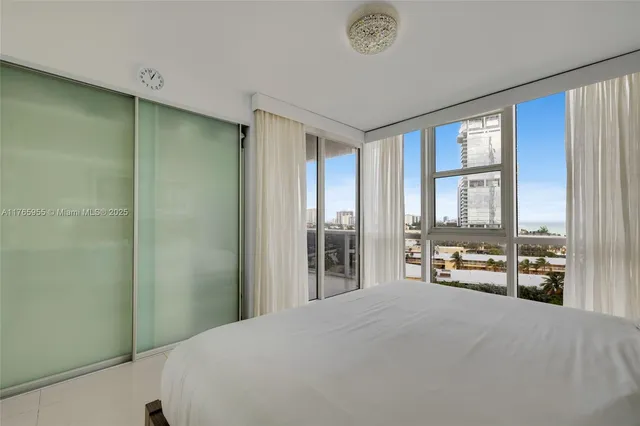 a bedroom with a bed and a large window