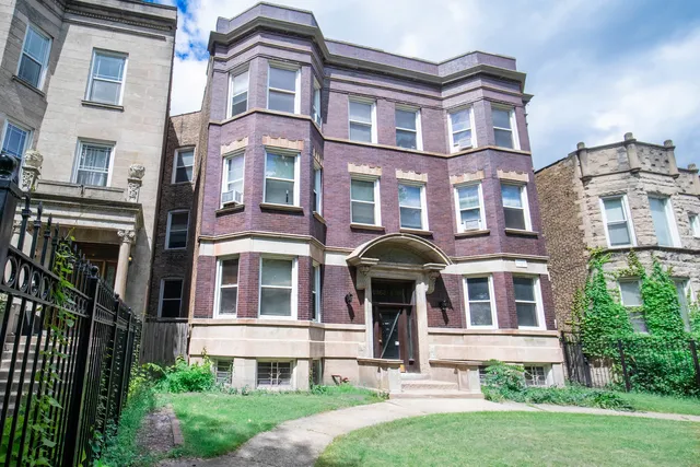 a front view of a residential apartment building with a yard