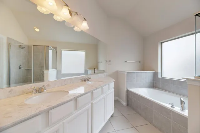 a bathroom with a granite countertop bathtub sink vanity and mirror