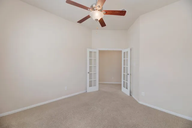 an empty room with closet and a chandelier fan