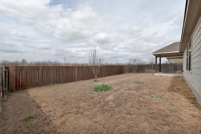 a backyard of a house with wooden fence