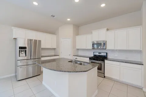 a kitchen with stainless steel appliances granite countertop a sink and cabinets