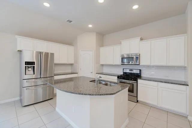 a kitchen with stainless steel appliances granite countertop a sink and cabinets
