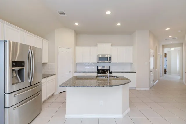 a kitchen with white cabinets stainless steel appliances and sink