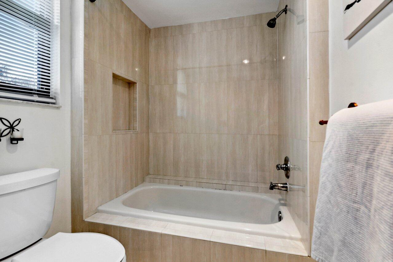 19867 Boca W Drive, Unit 3262 Boca Raton, FL 33434 - Photo 17 of 36 a bath room with a toilet and a bath tub