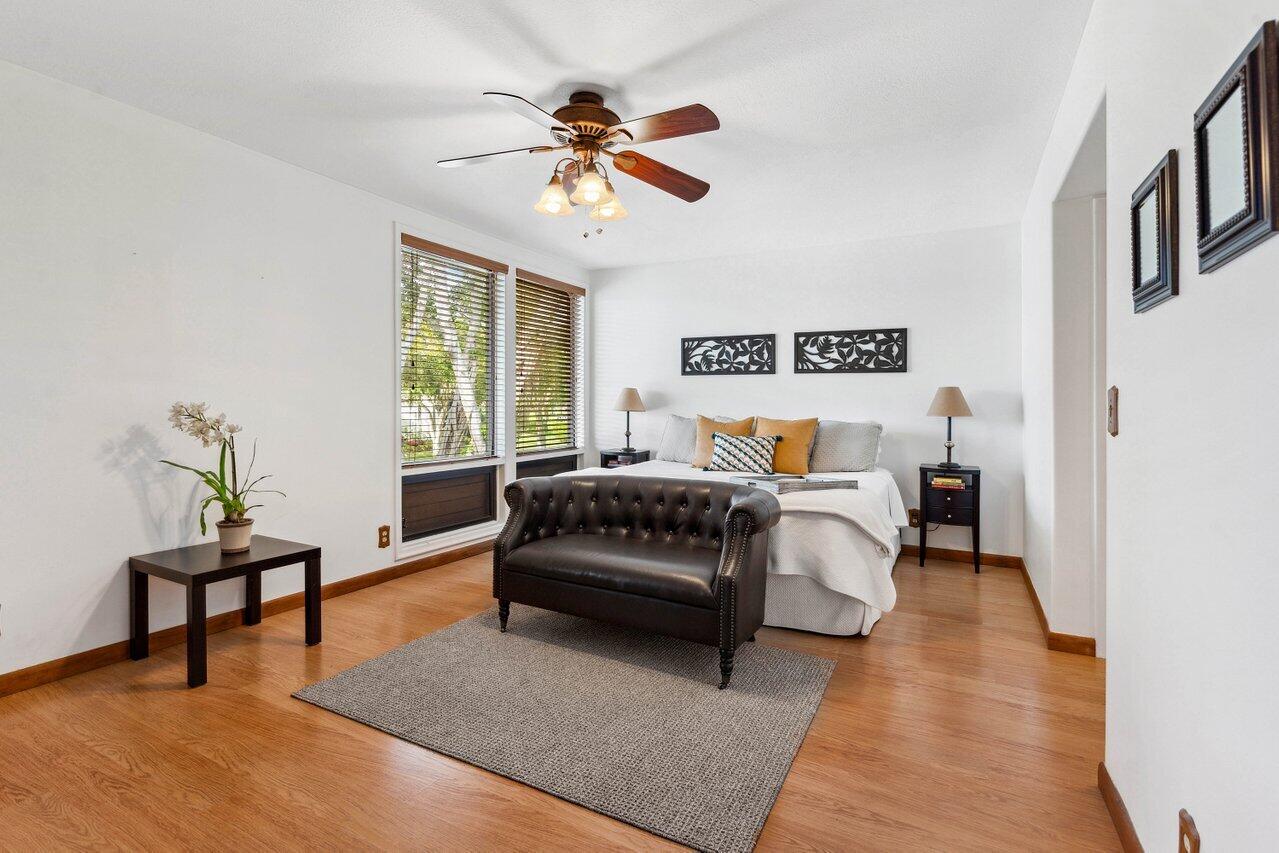 19867 Boca W Drive, Unit 3262 Boca Raton, FL 33434 - Photo 19 of 36 a bedroom with a bed and a chandelier