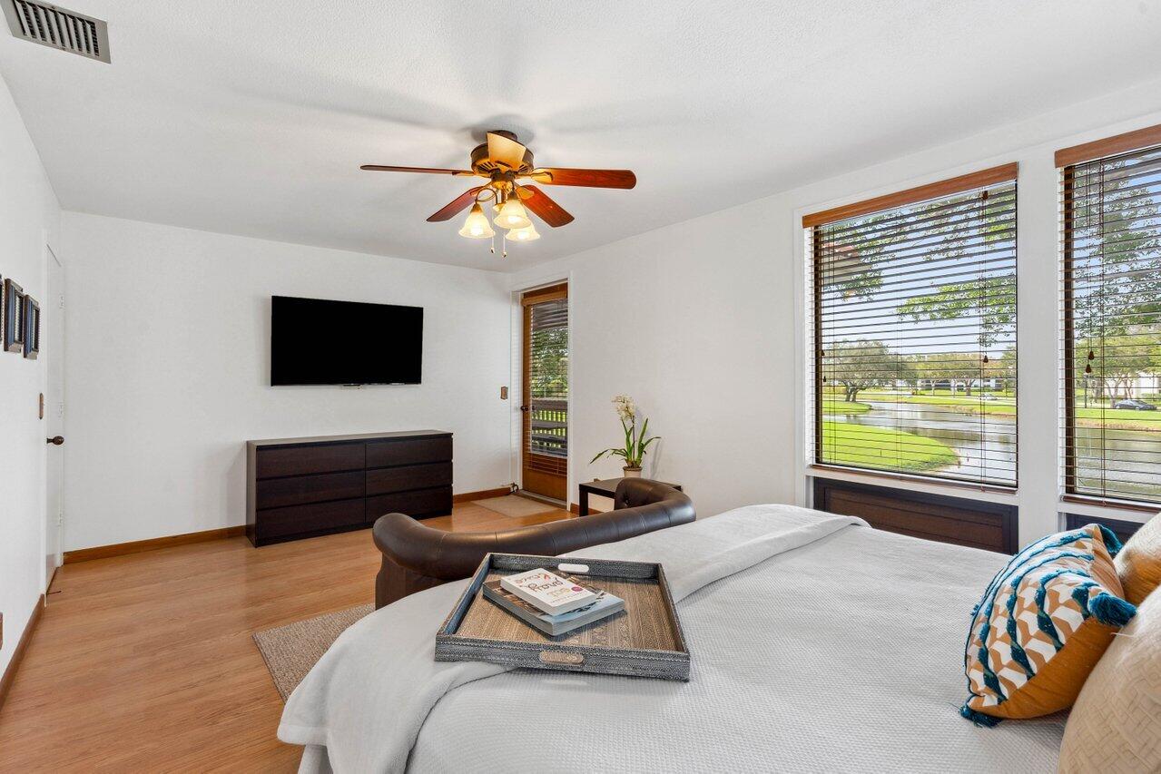 19867 Boca W Drive, Unit 3262 Boca Raton, FL 33434 - Photo 20 of 36 a bedroom with furniture and a flat screen tv