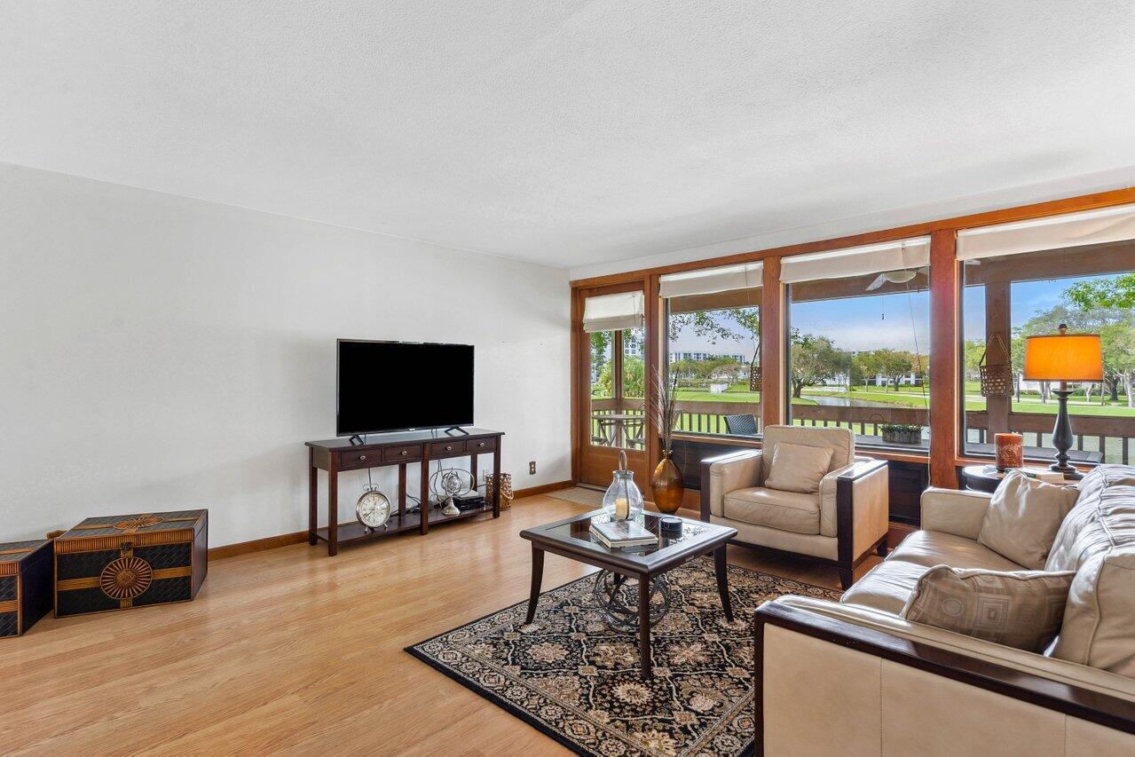 19867 Boca W Drive, Unit 3262 Boca Raton, FL 33434 - Photo 7 of 36 a living room with furniture and a flat screen tv