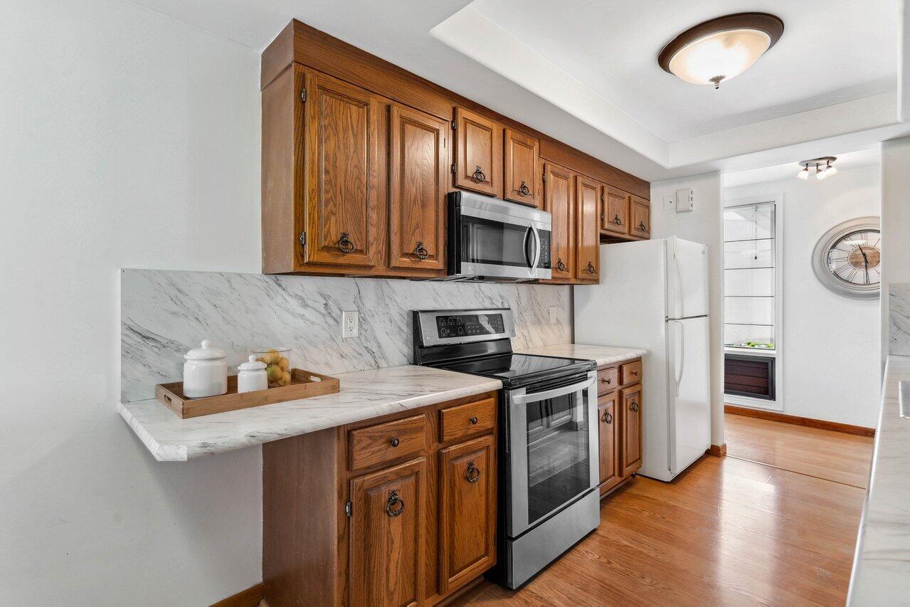 19867 Boca W Drive, Unit 3262 Boca Raton, FL 33434 - Photo 10 of 36 a kitchen with stainless steel appliances granite countertop a stove microwave and refrigerator