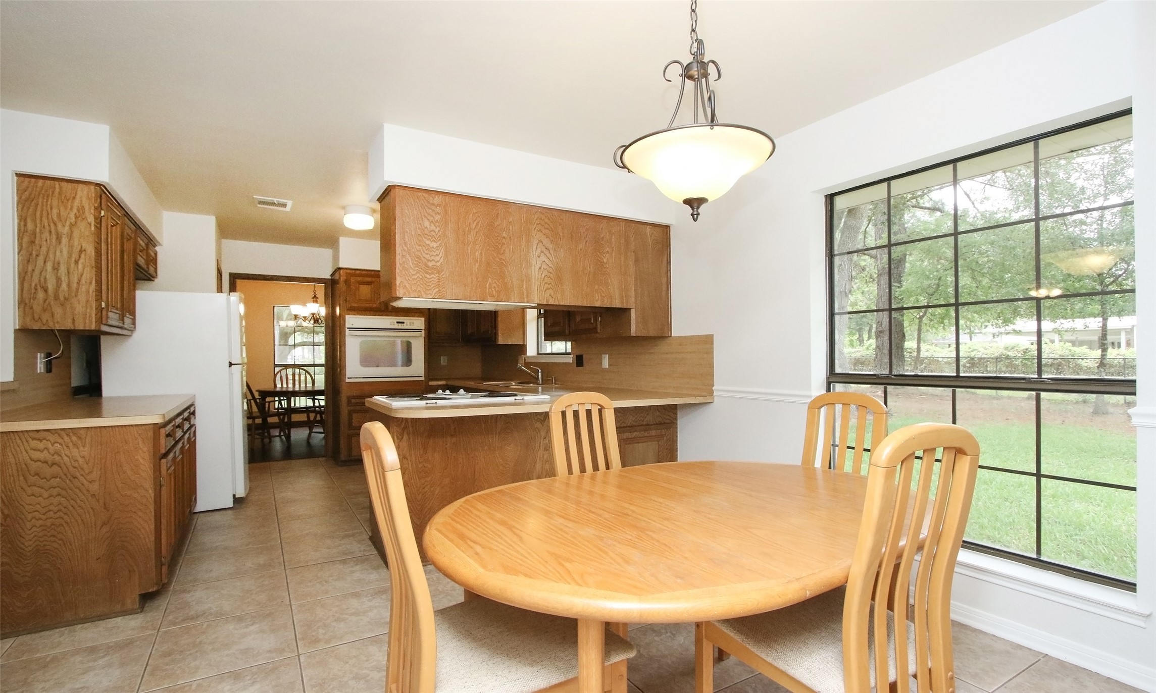 17406 Bobcat Trail Cypress, TX 77429 - Photo 11 of 28 a kitchen with stainless steel appliances granite countertop a stove a refrigerator a sink a dining table and chairs with wooden floor