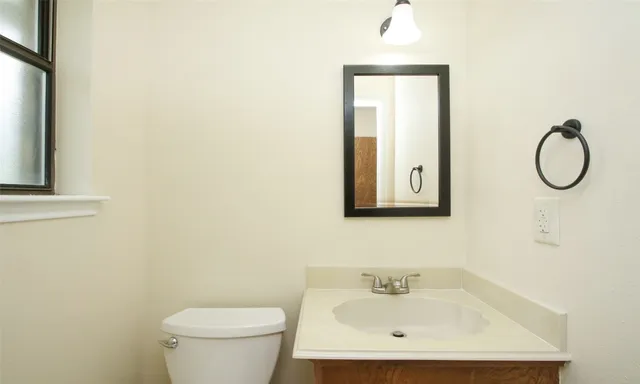 a bathroom with a toilet sink and mirror